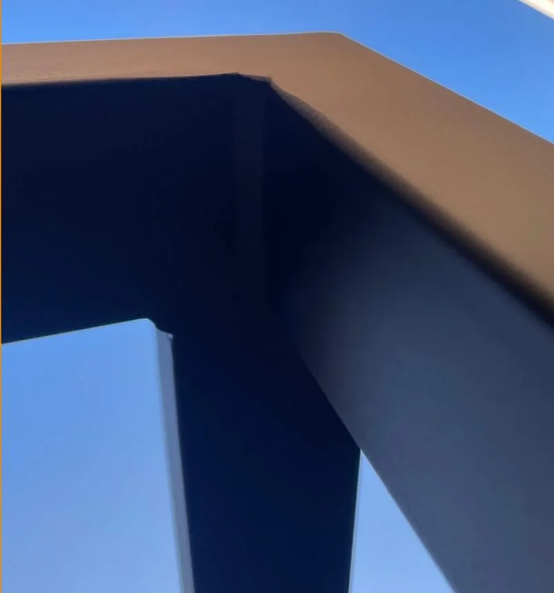 Detalhe de estrutura em metalon preto contra o céu, trabalho da Ferro Forte